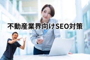 不動産業界向けSEO対策-メインビジュアル PCの前で携帯を持ち作業服を着た女性